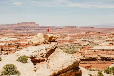 Woman hiker takes in the view on a ledge overlooking the maze utah