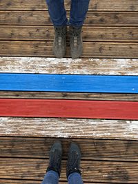 Low section of person standing on wooden floor