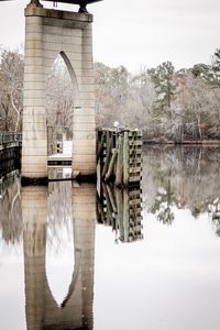 Reflection of bridge on river against sky