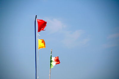 Low angle view of flag flags against blue sky