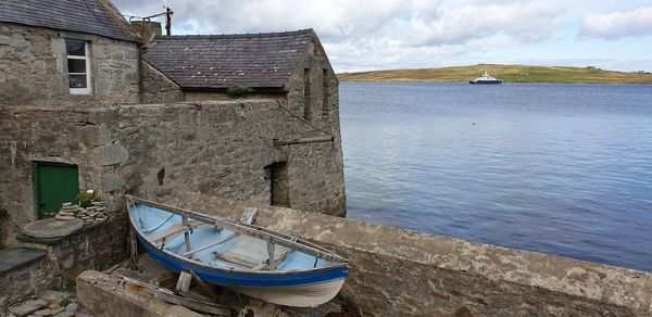 Ship moored on sea against buildings