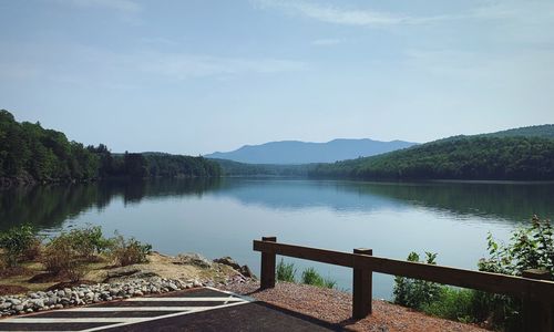 Scenic view of lake by mountains against sky