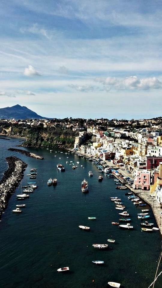 building exterior, nautical vessel, transportation, architecture, sky, water, mode of transport, built structure, city, boat, moored, sea, harbor, high angle view, cityscape, cloud - sky, residential district, mountain, river, town