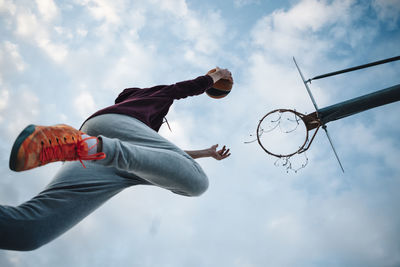 Young man playing basketball on an outdoor court