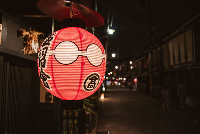 Close-up of illuminated lantern hanging in city at night