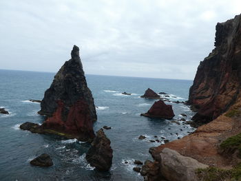 Rocks on sea shore against sky