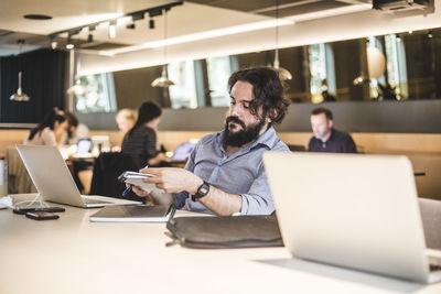 Male entrepreneur planning business strategies while working in office