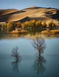 Scenic view of lake against mountain at sunset