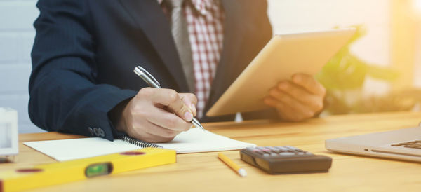 Midsection of man working on table