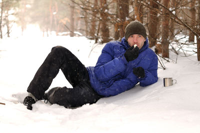 Full length of young man on snow covered field