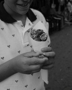 Midsection of woman holding ice cream standing outdoors