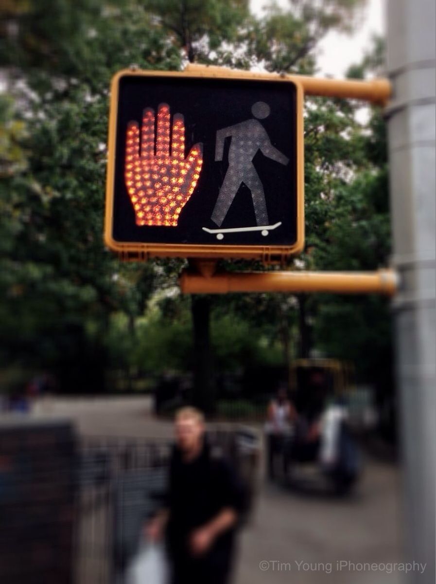 text, communication, western script, focus on foreground, sign, tree, men, non-western script, information sign, lifestyles, street, selective focus, leisure activity, capital letter, day, person, built structure, outdoors