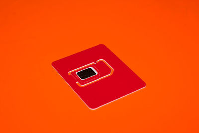 High angle view of telephone booth against orange background