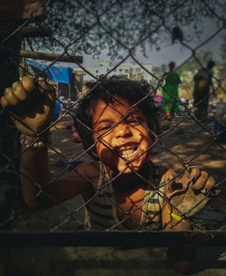Portrait of smiling girl by fence