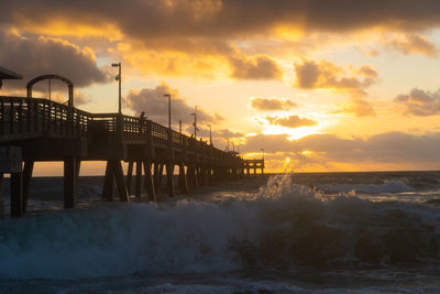 Pier over sea against sky during sunset