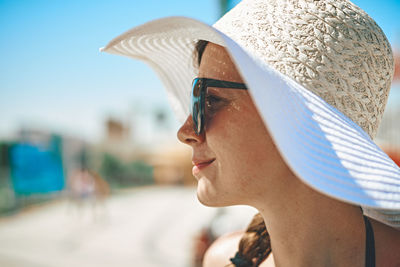 Close-up of woman wearing hat looking away outdoors