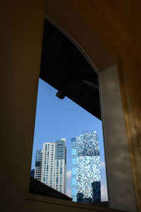 Low angle view of modern buildings against blue sky