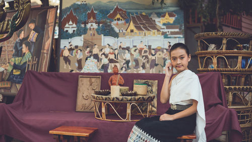 Portrait of girl sitting on sofa at table