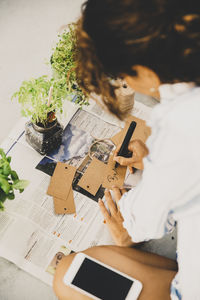 Woman writing label for plants at houseboat