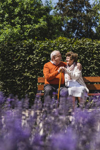 Senior couple sitting on bench in a park, falling in love