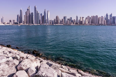 View of sea and cityscape against sky