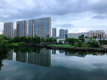 Reflection of buildings in lake against sky