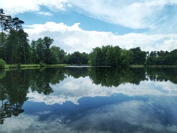 Scenic view of lake by trees against sky