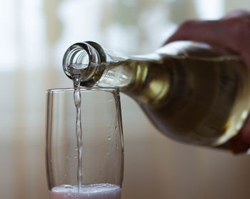 Close-up of hand pouring water in glass