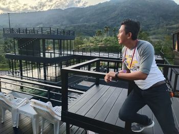 Portrait of young man standing on staircase