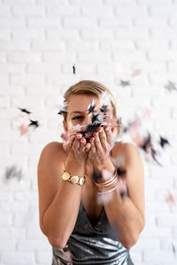 Portrait of woman standing against wall