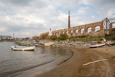 Boats moored in river against buildings in city