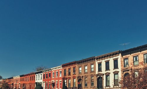 Low angle view of buildings against clear blue sky