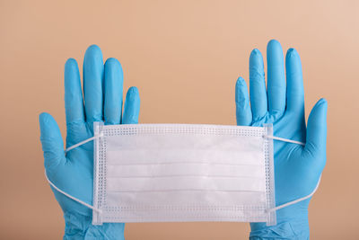 Close-up of hands on table against blue background