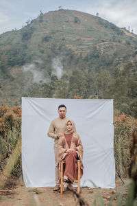 Romantic couple on the shores of a beautiful fogy lake and mountain in indonesian nature