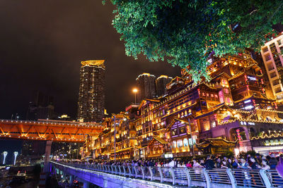 Illuminated buildings in city against sky at night