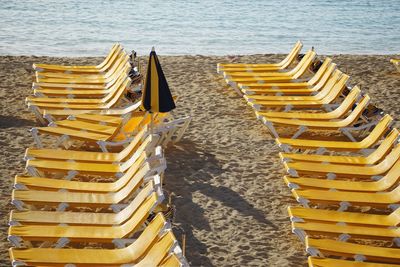Row of empty yellow chairs at beach