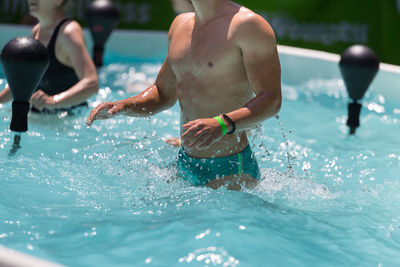 Midsection of people in swimming pool