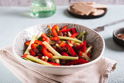 Vegetarian salad of red beans, cucumber and bell pepper in a bowl on the table