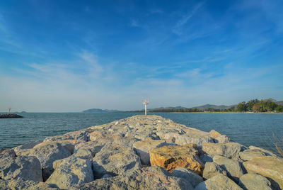 Panoramic view of rock by sea against blue sky