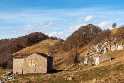 Houses in mountain linzone landscape against clear sky in winter