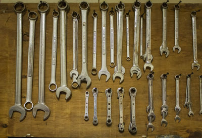 Various work tools hanging on wooden wall in workshop