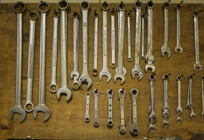 Various work tools hanging on wooden wall in workshop