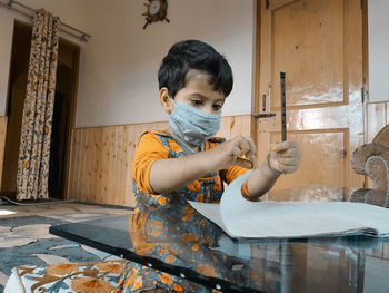 Boy wearing mask holding paper