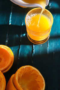 Freshly made orange juice in a ceramic squeezer, poured into a crystal