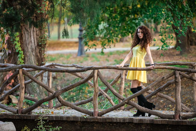 Portrait of smiling young woman against trees