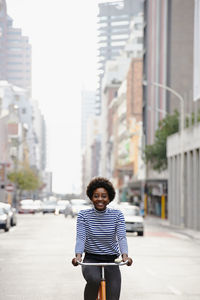 Full length portrait of man standing on road in city