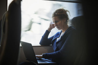 Businesswoman using laptop in train