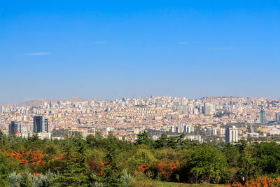 Buildings in city against clear blue sky