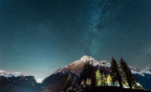 Scenic view of snowcapped mountains against sky at night