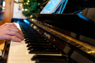 Cropped hands of person playing piano